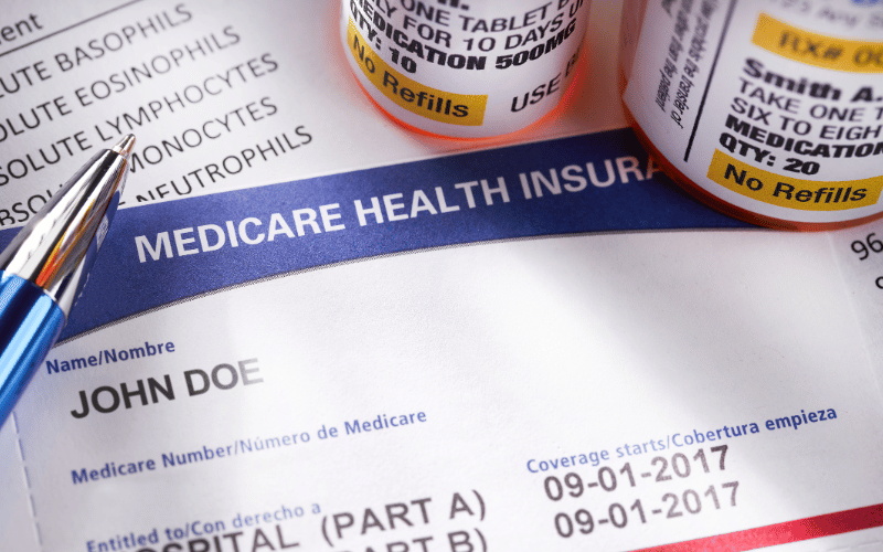 a closeup of a medicare card and various prescription bottles next to it